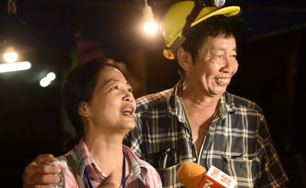 Familiares de los niños atrapados en una cueva en Tailandia celebran a la entrada de la misma.