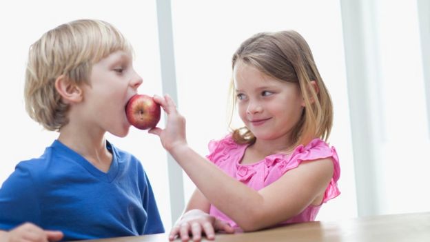 Niños comiendo una manzana