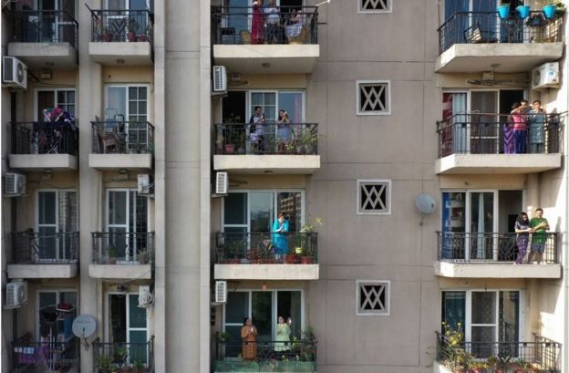 People gathering in their balconies of a residential building in Ghaziabad, India