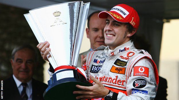 Fernando Alonso celebrates winning the 2007 Monaco Grand Prix by raising the trophy