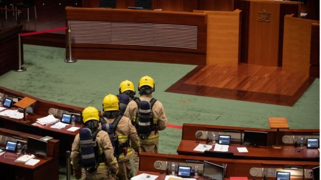 Firefighters wearing gas masks check the main chamber of the Legislative Council in Hong Kong, China, 28 May 2020