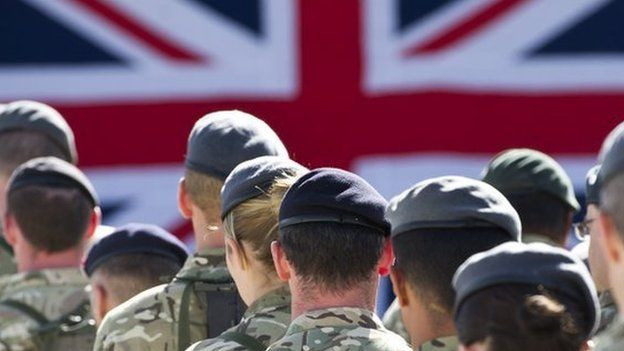 Male and female members of the armed forces gathered together for a remembrance service.