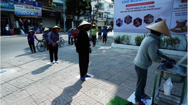 People queuing up to collect rice from a rice ATM.