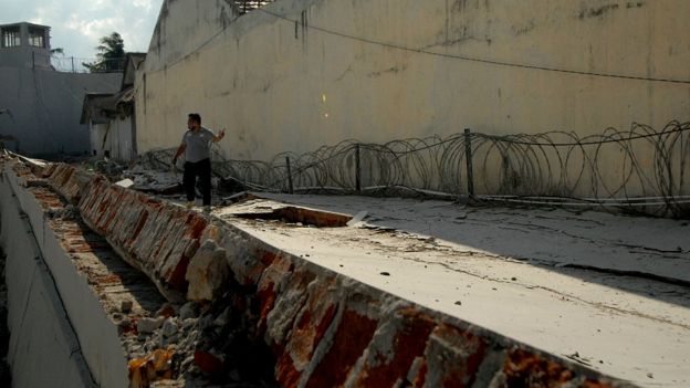 An officer walks at a collapsed prison wall following an earthquake in Palu, Central Sulawesi, Indonesia, October 2, 2018