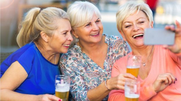 mulheres tirando uma selfie e com copos de cerveja na mÃ£o