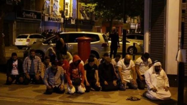 Muslim men pray on the street in the aftermath of the van attack