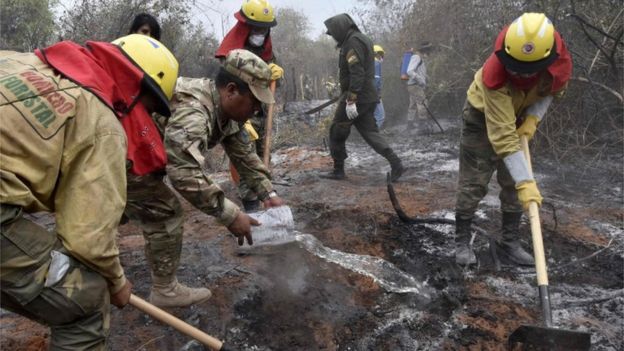 Trabajadores apagan incendios en Bolivia.