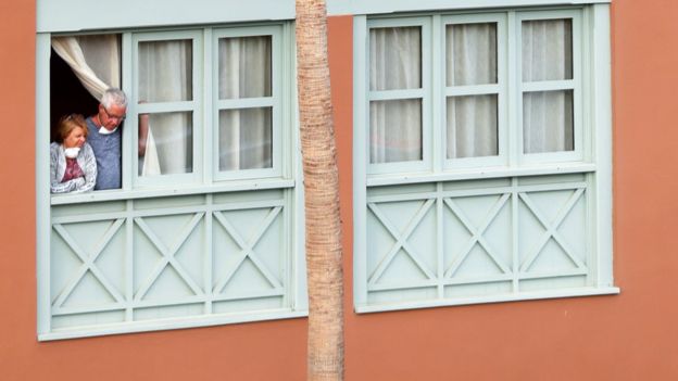Tourists looks through a window of the H10 Costa Adeje Palace hotel, which is on lockdown after novel coronavirus has been confirmed in Adeje, on the Spanish island of Tenerife, Spain