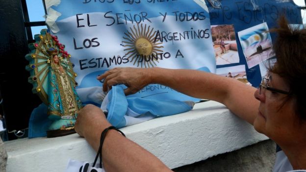 Una mujer frente a una bandera argentina que pide por los marinos de ARA San Juan.