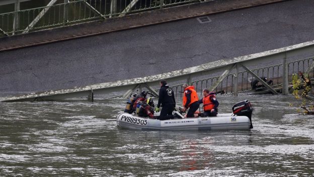 Rescuers at work to recover victims after a suspension bridge collapsed over the Tarn river