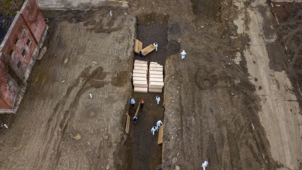 Drone pictures show bodies being buried in a wide trench on New York's Hart Island