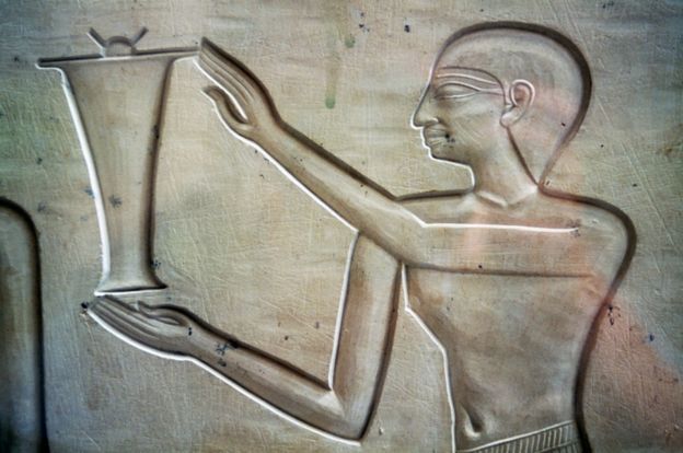Ilustración de un hombre llevando una jarra de aceite de 2050 a.C.