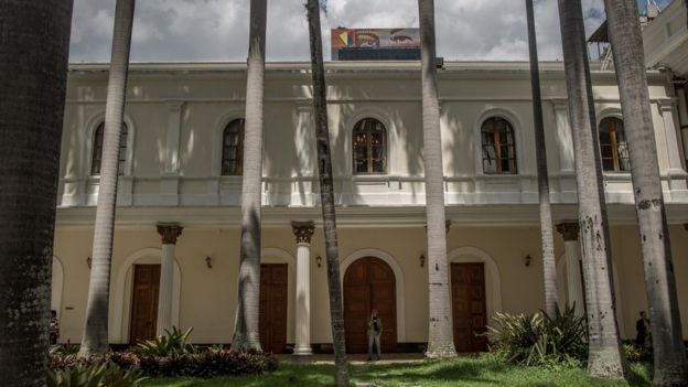 A view of the National Assembly building with a poster of Hugo Chávez's eyes