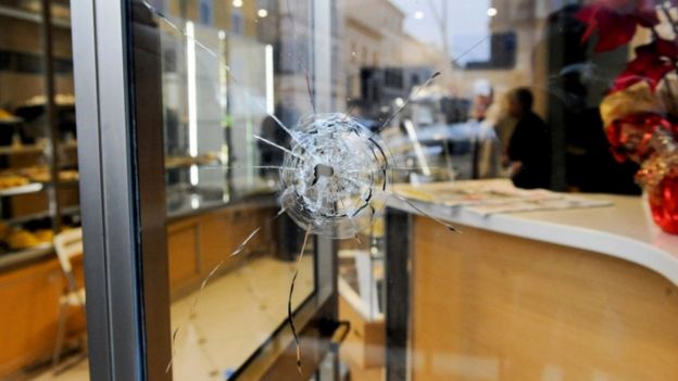 A bullet hole in a shop window as police investigate the shooting of foreign nationals at Macerata, 3 February 2018