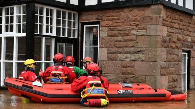 Mountain Rescue team members attempt to rescue a man from his house that is surrounded by heavy flood water in Monmouth, in the aftermath of Storm Dennis