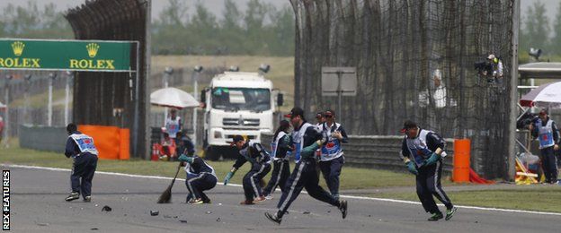 Stewards sweep up debris at the Chinese Grand Prix