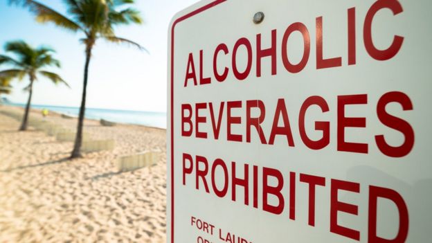 Placa em praia com dizeres, em inglês: 'Alcoholic beverages prohibited'