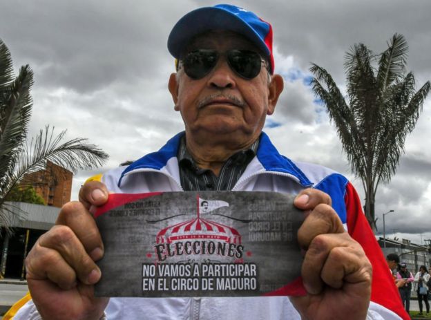 Hombre con cartel que dice: "No vamos a participar en el circo de Maduro"