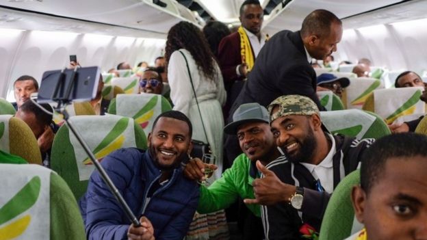 Passengers pose for a selfie picture inside an Ethiopian Airlines flight who departed from the Bole International Airport in Addis Ababa, Ethiopia, to Eritrea"s capital Asmara on July 18, 2018