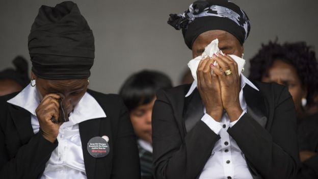 Widows cry on August 16, 2014, in Marikana, during a ceremony in tribute to miners who where gunned down by the South African police during a violent wave of strikes two years ago.