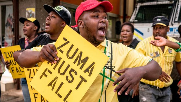 Supporters of the African National Congress Deputy President Cyril Ramaphosa hold placards and chant slogans outside the ANC party headquarter in Johannesburg, on February 5, 2018,