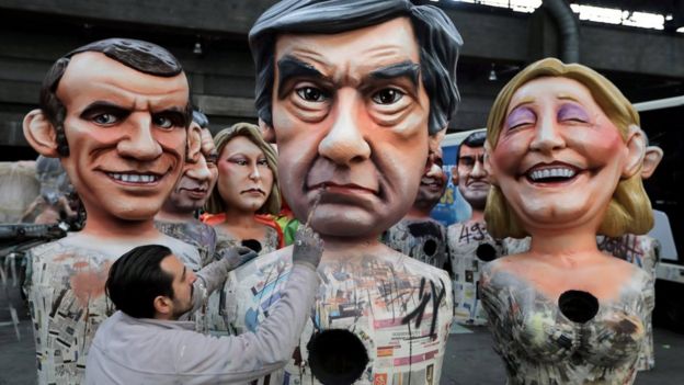 A worker puts the final touches to a giant figure of Francois Fillon (C), former French prime minister, member of The Republicans political party and 2017 presidential candidate of the French centre-right, next to French National Front leader Marine Le Pen (R) and Emmanuel Macron (L), head of the political movement En Marche !, or Onwards !, during preparations for the carnival parade in Nice, France, 2 February 2017
