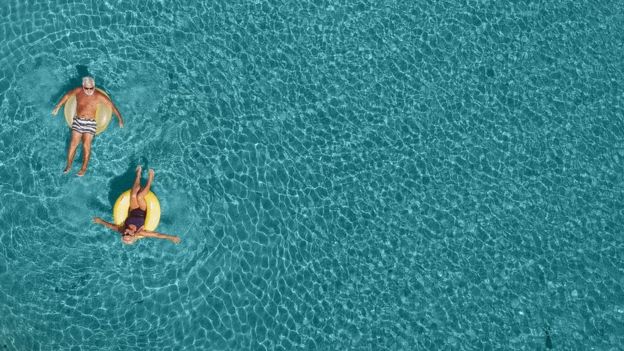 Una pareja de adultos e el mar.