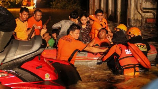 Equipe de resgate retira moradores de Davao, na ilha Mandanao, em um bote