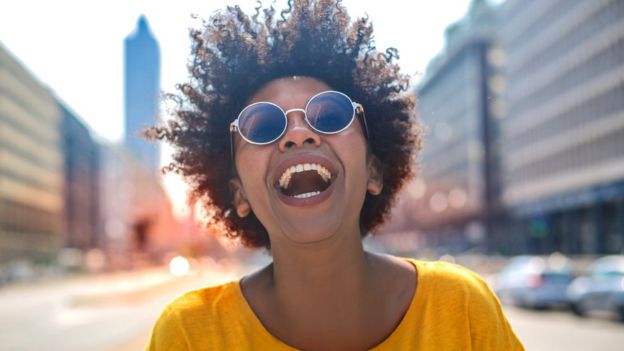 Mujer sonriente bajo un día soleado.