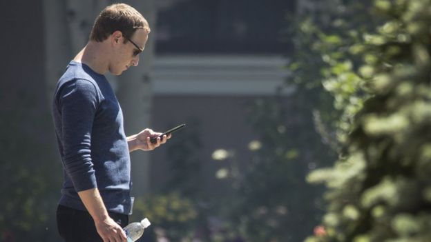 Mark Zuckerberg revisando su teléfono.