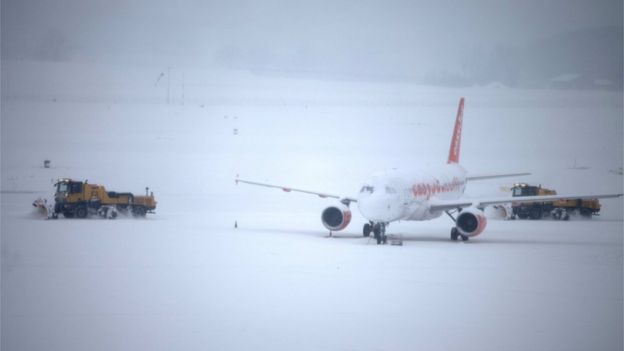Snow plough removes snow next to an EasyJet aircraft during a temporary closure at Cointrin airport in Geneva, Switzerland, 1 March 2018