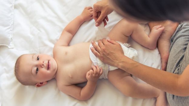 Mãe trocando fralda de bebê