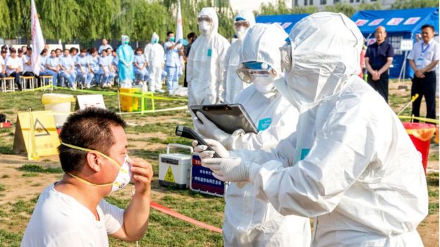 Un hombre en China con gripe es atendido por personal sanitario.