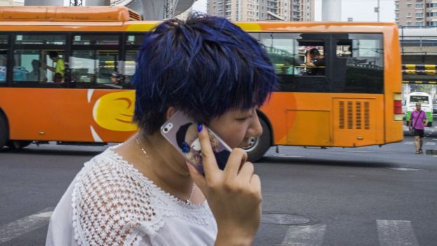 Woman talking into a mobile phone while crossing the road