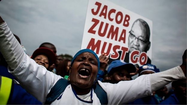 A Democratic Alliance (DA) party's supporters holds a placard reading 'Jacob Zuma must go' during a march against South African president Jacob Zuma on April 7, 2017 in Johannesburg.