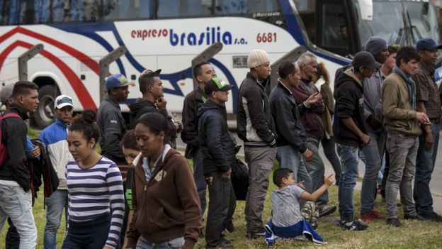 Migrantes venezuelanos aguardando atendimento em um campo improvisado em Bogotá, na Colômbia
