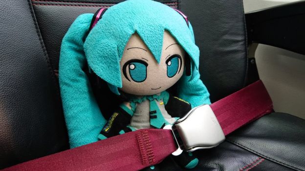 Miku, con el cinturón abrochado en su asiento del avión