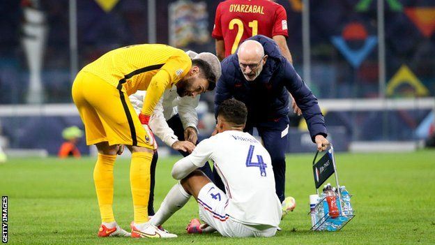 Raphael Varane sits on the grass after picking up an injury during France's Nations League final win against Spain