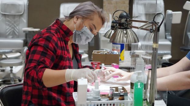 Debi Dang travaille sur les ongles d'un client au Allure Nail Bar à Atlanta, en Géorgie, le 24 avril 2020.