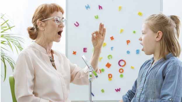 Mujer madura y niña practican la fonética.