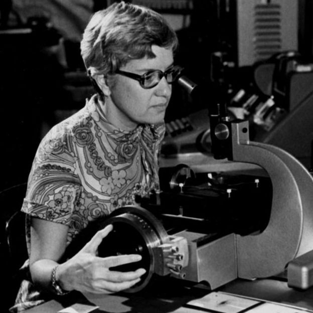 Vera Rubin observa con un microscopio.