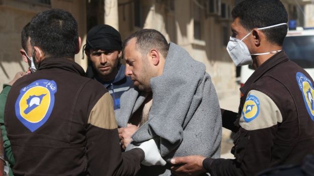 A man is helped by rescue workers following a suspected chemical attack in Khan Sheikhoun, Idlib province, Syria (4 April 2017)