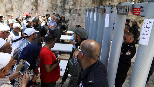 Palestinians stand in front of Israeli policemen and newly installed metal detectors at an entrance to the compound known to Muslims as Noble Sanctuary and to Jews as Temple Mount, in Jerusalem's Old City 16 July, 2017