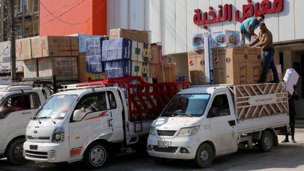 Iraqi men unload air conditioners and electrical appliances imported from Iran in Baghdad (23 February 2019)
