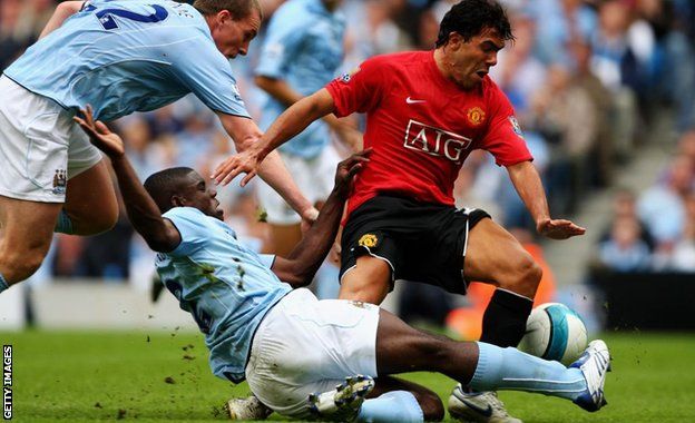 Micah Richards tackles Carlos Tevez during City's win over United in the Manchester derby in August 2007