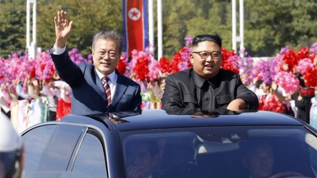 Moon Jae-in (izquierda) y Kim Jong-un saludan.