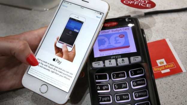JULY 14: In this photo illustration, an iPhone is used to make an Apple Pay purchase at The Post Office on July 14, 2015 in London, England