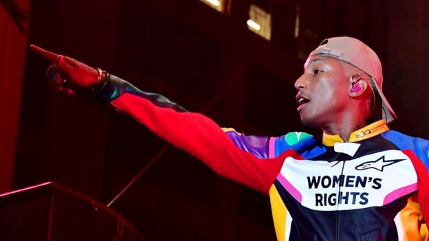 Pharrell Williams at a concert wearing a T-shirt saying "Women's Rights"