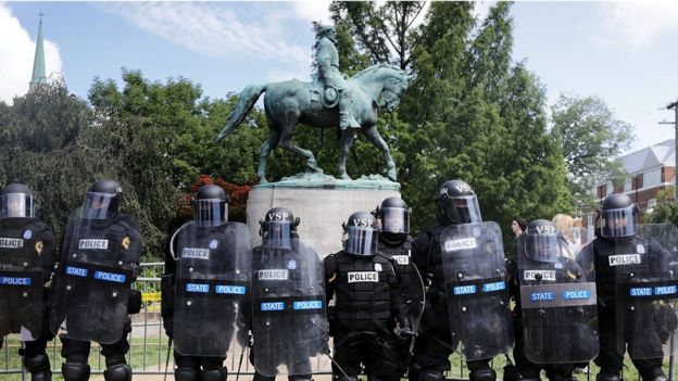 Police guard the statue of General Robert E Lee in Charlottesville on 12 August