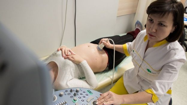 Una doctora haciéndole ultrasonido a una paciente.